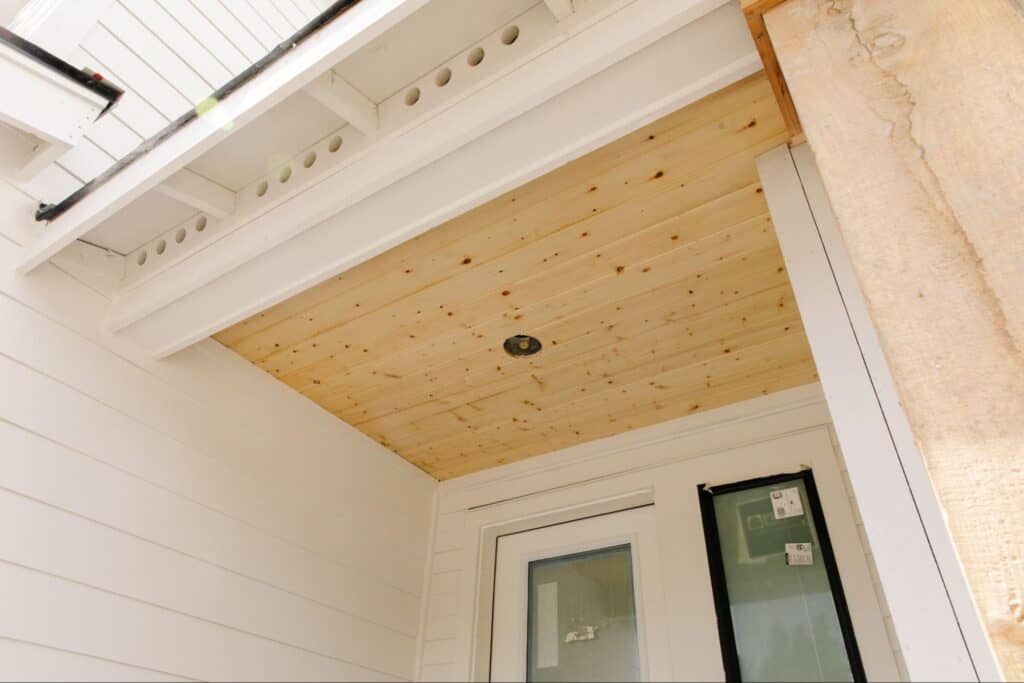 Natural wood porch ceiling, featuring tongue and groove accents