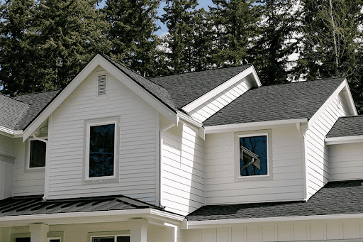 A new two-story home with white trim and siding and a black roof.