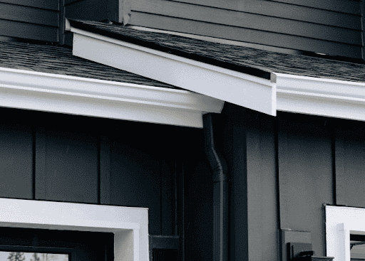 Close-up of white preservative-treated fascia board on a charcoal home.