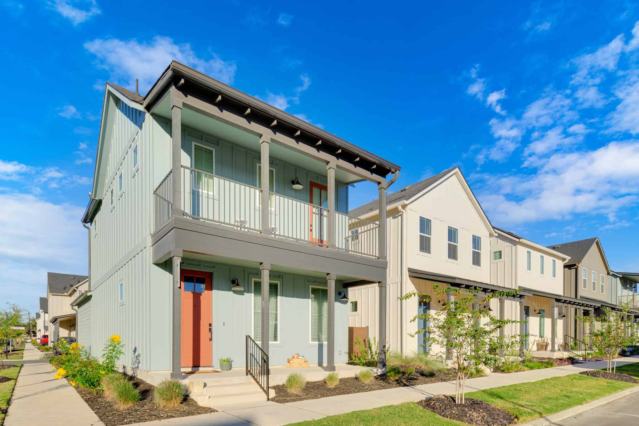 Exterior of a gray modern home at Birdsong Ranch, TX, showcasing Belco XT posts on two covered porches.